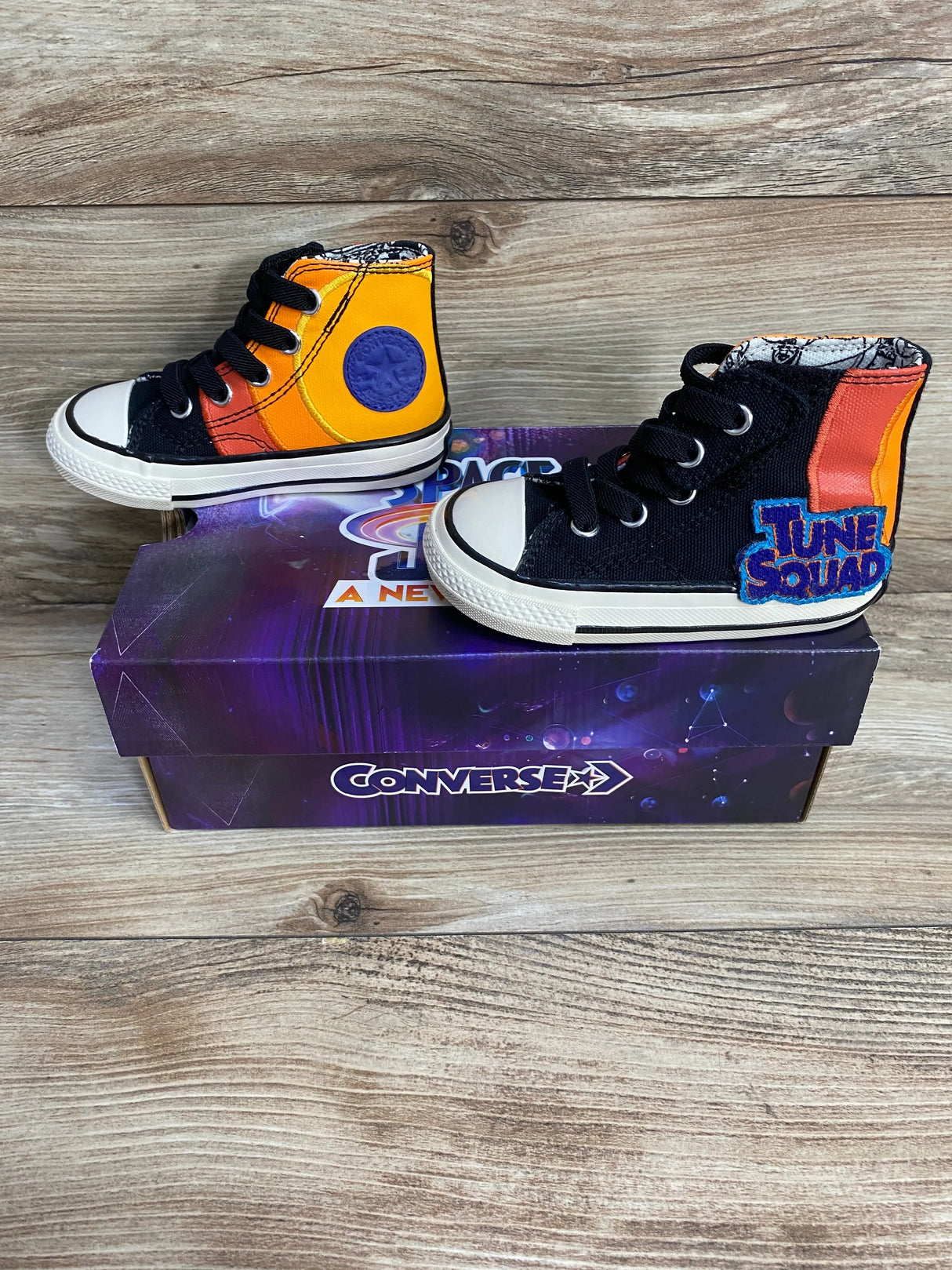 Side view of Converse 70 Hi sneakers (5C) showing black canvas, orange Space Jam panels and Tune Squad patch on Converse box