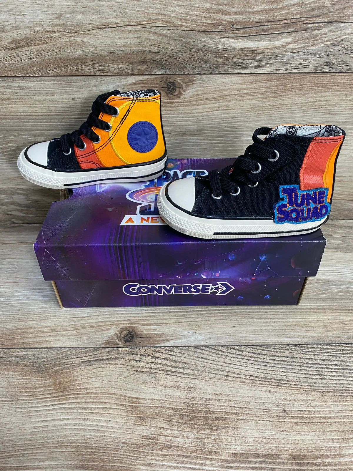 Side view of Converse 70 Hi sneakers (5C) showing black canvas, orange Space Jam panels and Tune Squad patch on Converse box