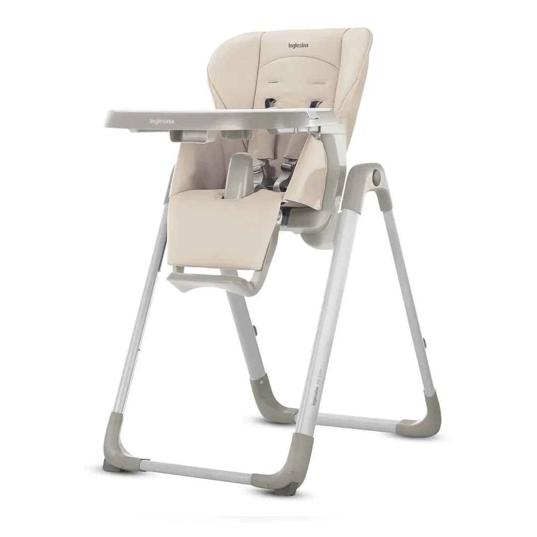 Inglesina beige baby high chair with adjustable tray, safety harness, and footrest on white frame
