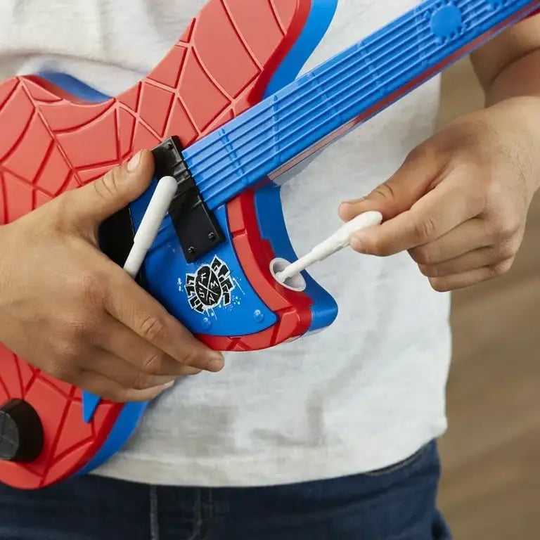 Child playing with red and blue Spider-Man themed toy guitar