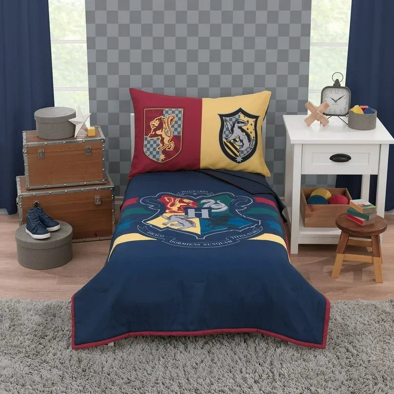 Front view of toddler bed set showcasing navy duvet with large Hogwarts crest and two house crest pillowcases in staged bedroom