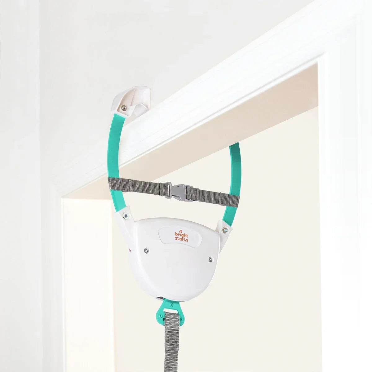 Front view of Bright Starts Playful Parade door jumper with white seat and logo, teal support arms, and gray safety strap on a white door frame