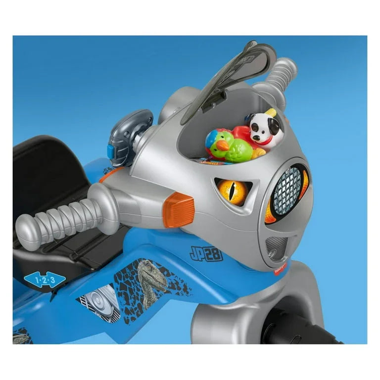 Front view of Fisher-Price Velociraptor tricycle showing dinosaur face, handlebars and toy storage on blue background