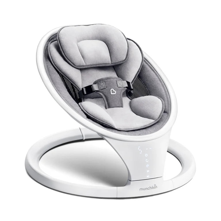 Three-quarter view of Munchkin baby swing with gray plush seat, padded head support, safety harness, and white ring base