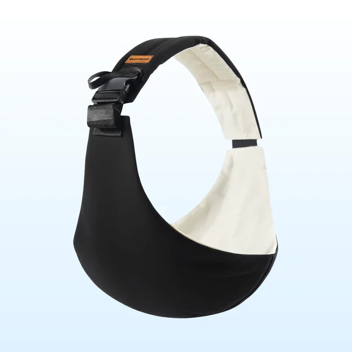 Angled front view of Bambora sling carrier with black exterior, cream inner lining, padded adjustable strap and buckle