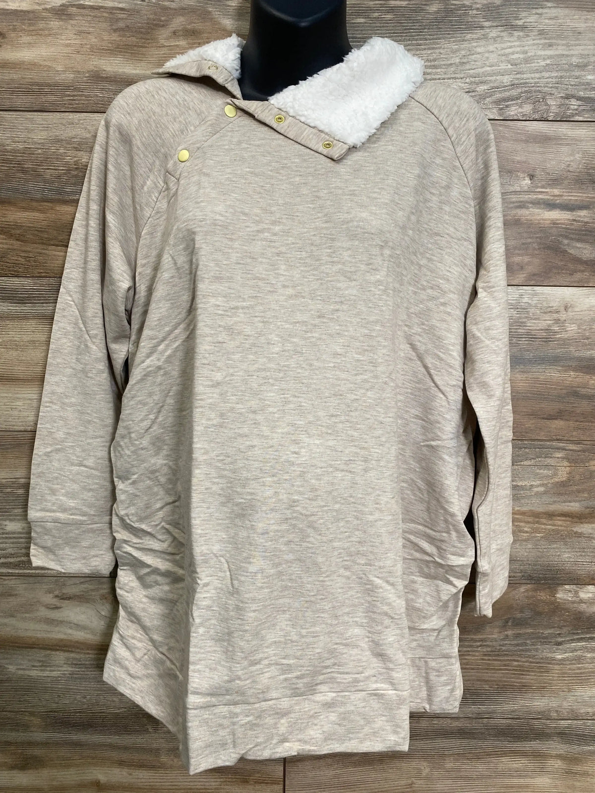 Front view of Isabel maternity oatmeal sweatshirt showcasing white sherpa snap collar and gold snaps on wood background