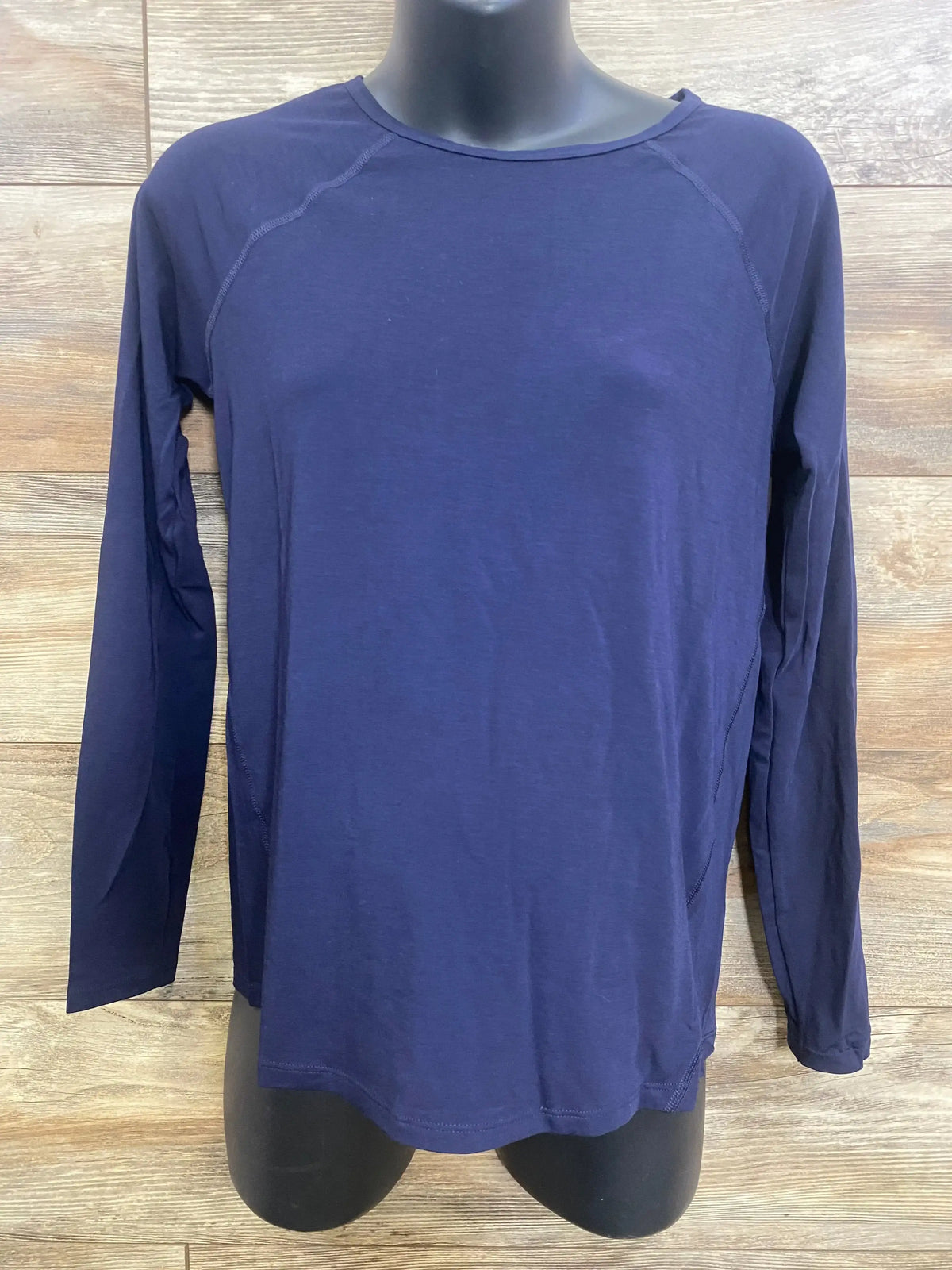 Front view of navy Gap maternity long-sleeve shirt size XS showing raglan sleeves and lightweight knit on wood background