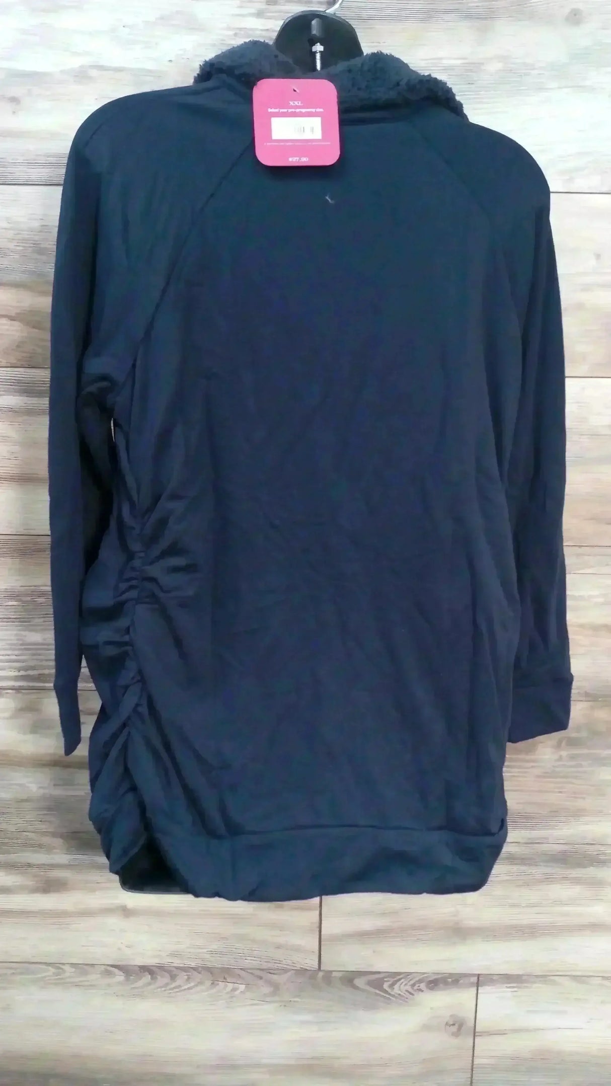 Back view of Isabel maternity navy sweatshirt showcasing sherpa collar, side ruching and XXL size tag on wood plank background
