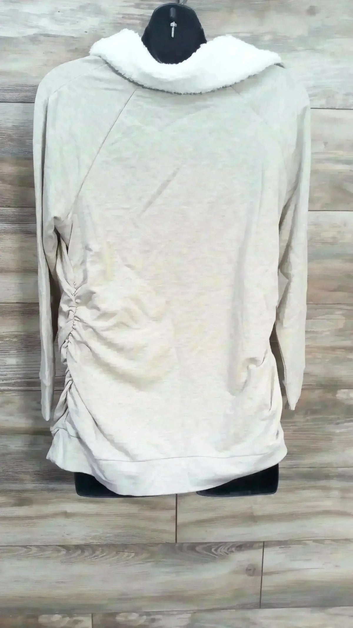 Back view of Isabel maternity oatmeal sweatshirt, size XL, showing sherpa collar and side ruching on wood background