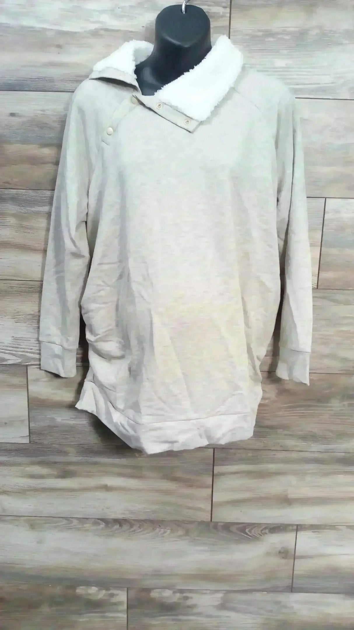 Front view of oatmeal maternity sweatshirt with sherpa snap collar, snap shoulder detail, and long sleeves on mannequin against wood plank background