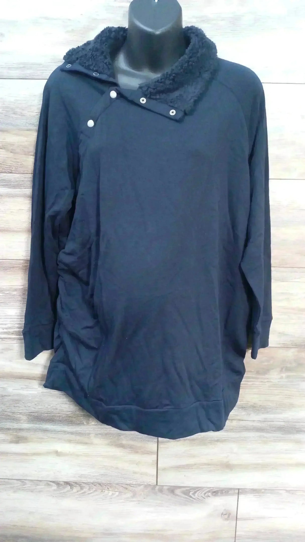 Front view of navy Isabel maternity sweatshirt showing sherpa-lined snap collar and long sleeves on a wood plank background