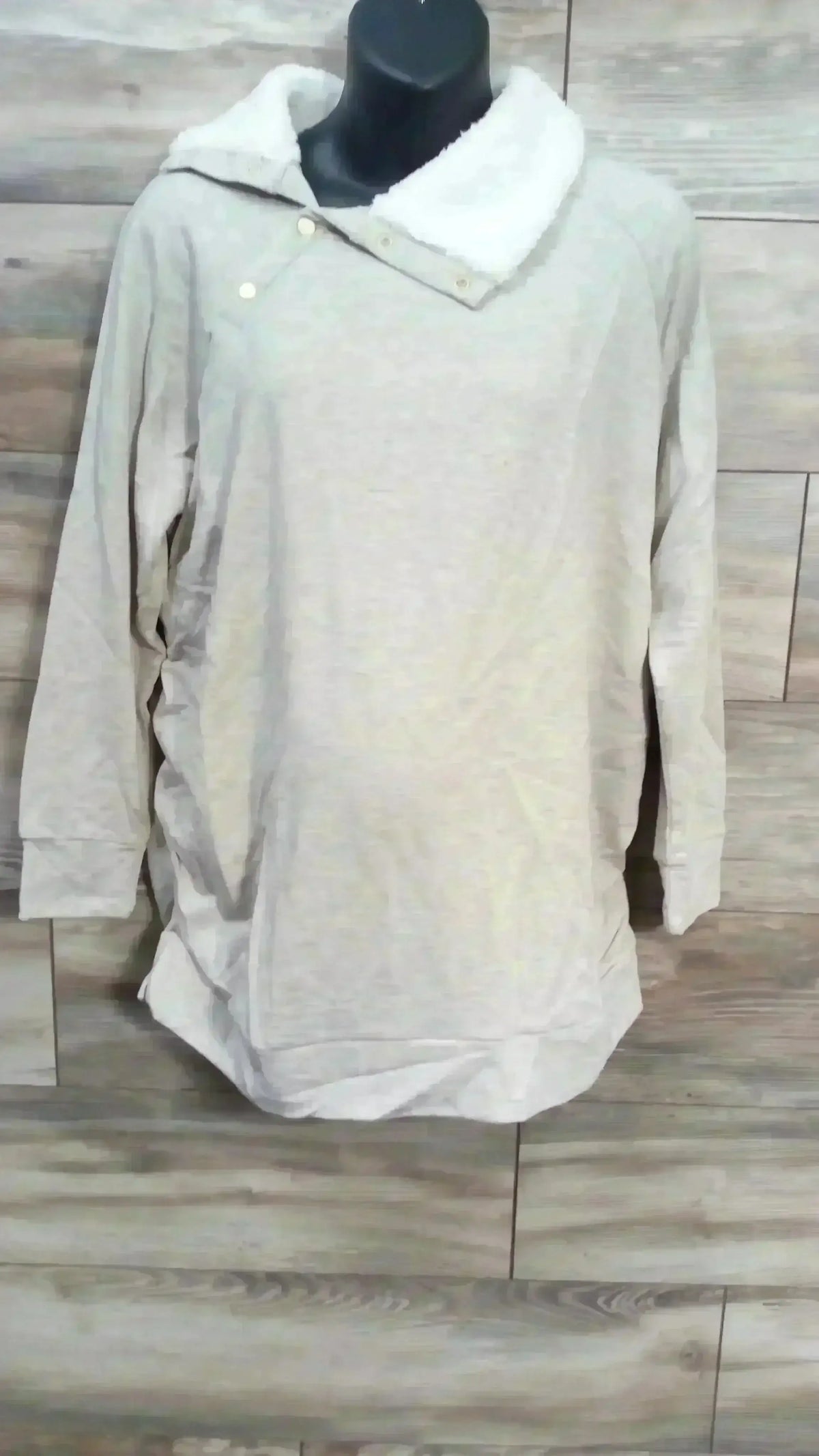 Front of Isabel maternity oatmeal sweatshirt with white sherpa snap collar, long sleeves, side ruching on wood background