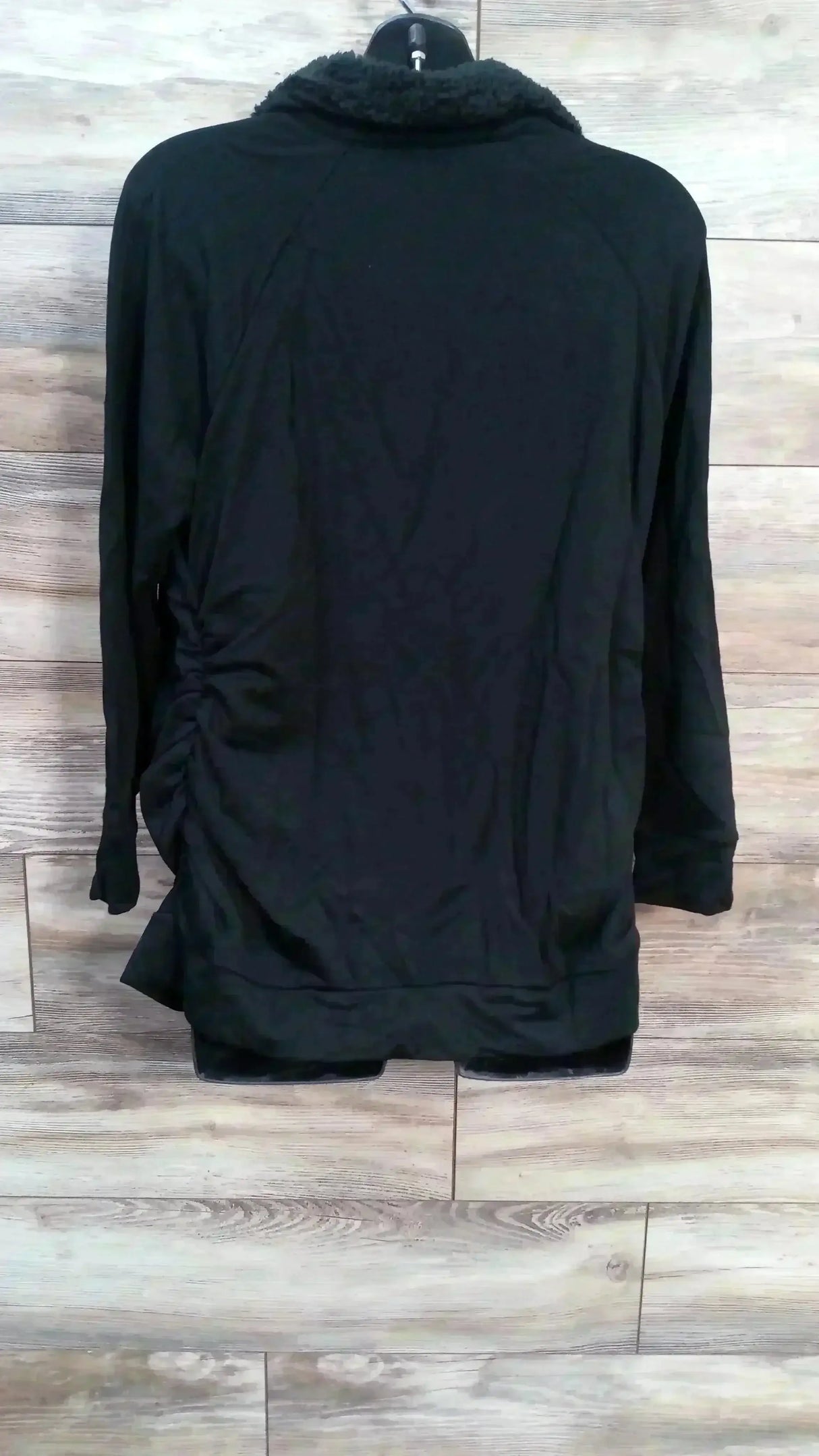 Back view of NWT Isabel Maternity sweatshirt sz XL showcasing black knit with side ruching and sherpa collar on mannequin on wood plank floor