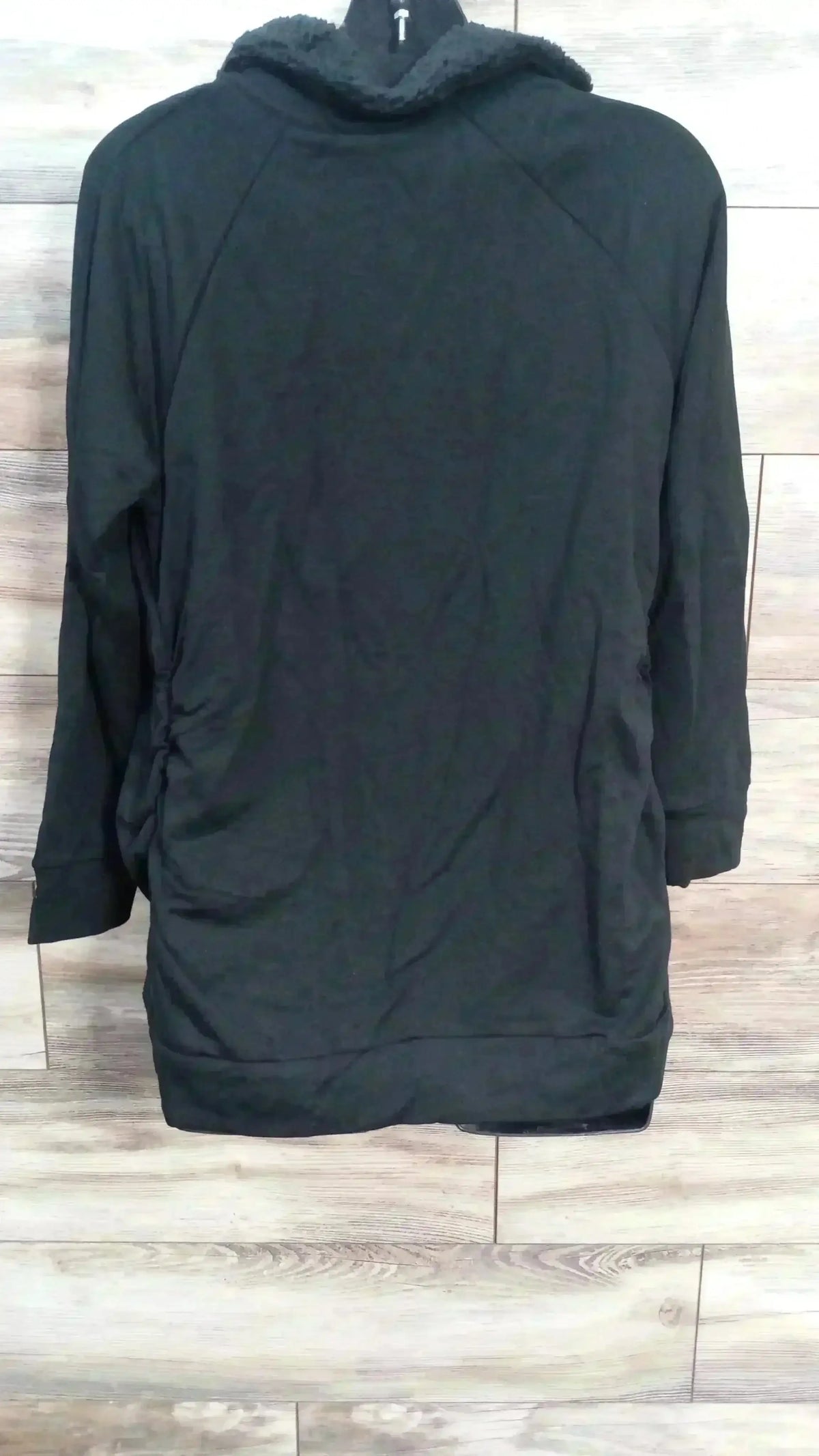Front view of black Isabel maternity sweatshirt showing sherpa-lined snap collar and side ruching against light wood background