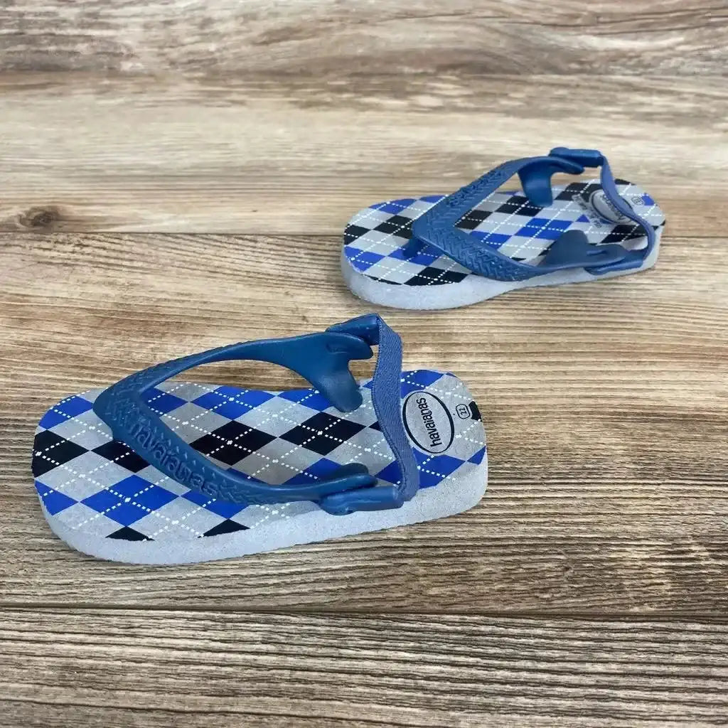 Angled view of Havaianas flip flops sz 8c showcasing blue argyle footbeds and elastic back on a wood-grain surface