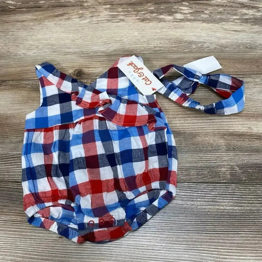 Top down view of Cat and Jack plaid baby romper with ruffle collar, snapped bottom and headband on wood background