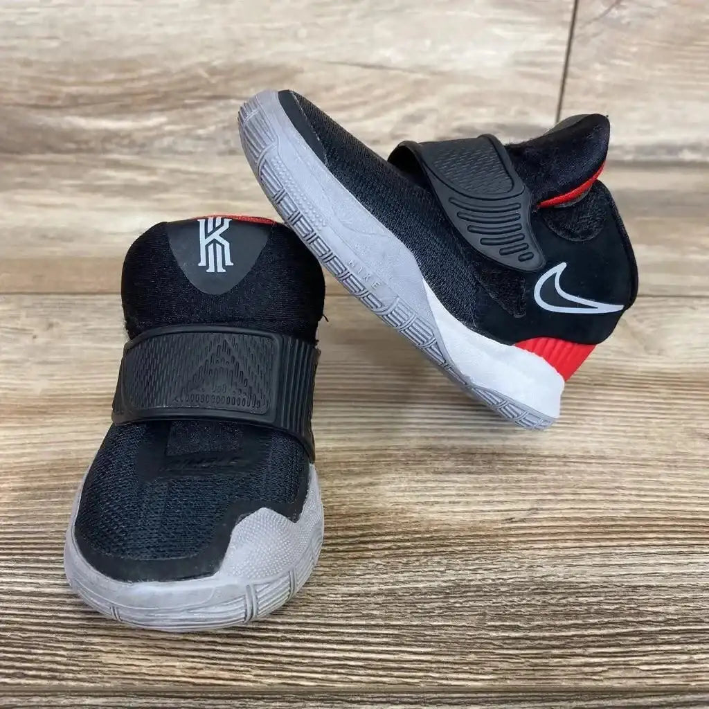 Front and side view of black Nike Kyrie 6 sneakers, size 4C, showing midfoot strap, gray sole, and red heel on a wood floor