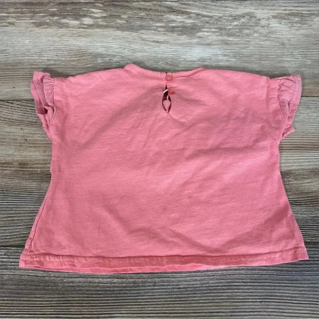 Back view of pink Zara baby shirt 3-6 months showing keyhole button closure and ruffle sleeves on wood background