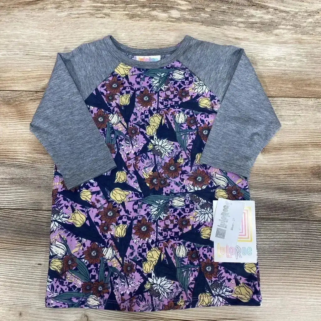 Front view of NEW LuLaRoe Raglan Sloan Shirt sz 2T showcasing gray raglan sleeves and purple floral print with wood-look background