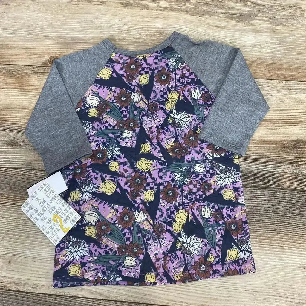 Top view of NEW LuLaRoe Raglan Sloan Shirt sz 2T showcasing gray raglan sleeves and purple floral print with wood background