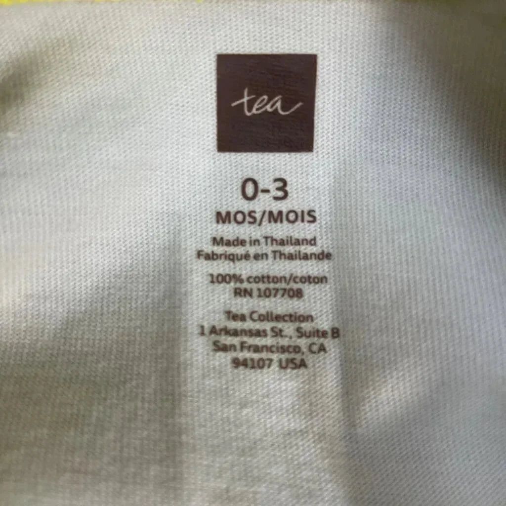 Close-up of Tea Collection coverall label showing size 0-3 months, brand logo and 100% cotton text on white fabric