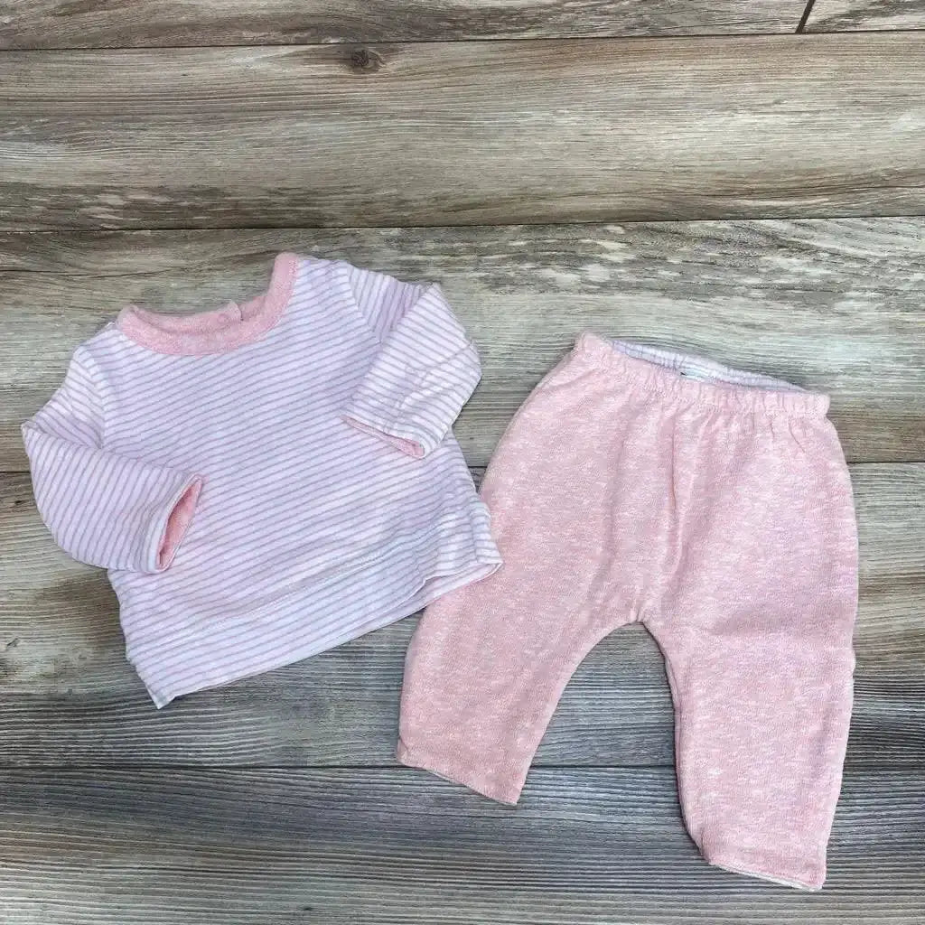 Flat lay of BabyGap 2-piece reversible outfit 0-3M striped long-sleeve top and solid pink elastic-waist pants on gray wood