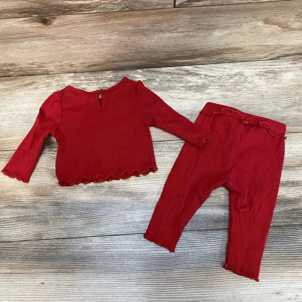 Flat lay of BabyGap red 2-piece ribbed shirt and pants showing lettuce edge hems and long sleeves on wood background
