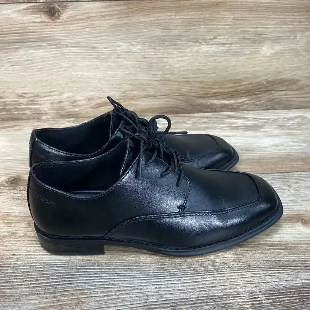 Side view of black Sonoma kids' dress shoes (size 4Y) showcasing lace-up front and low heel on a wood floor background