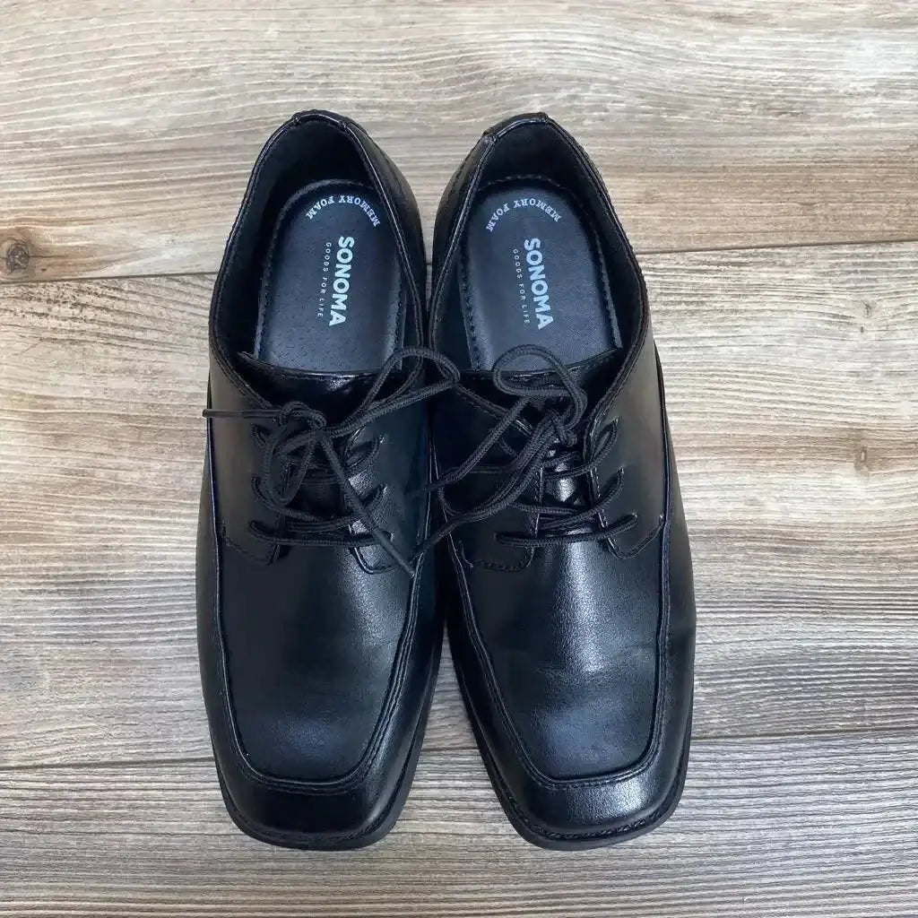 Top view of black Sonoma dress shoes youth size 4 showcasing square toe and lace up detail on light wood floor