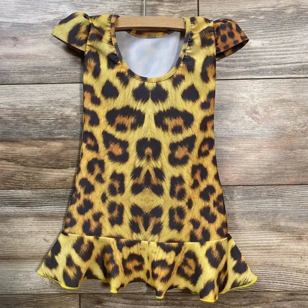 Front view of toddler leopard-print cap-sleeve dress (size 2T) showcasing ruffled hem and bold tan-and-black print on wood background