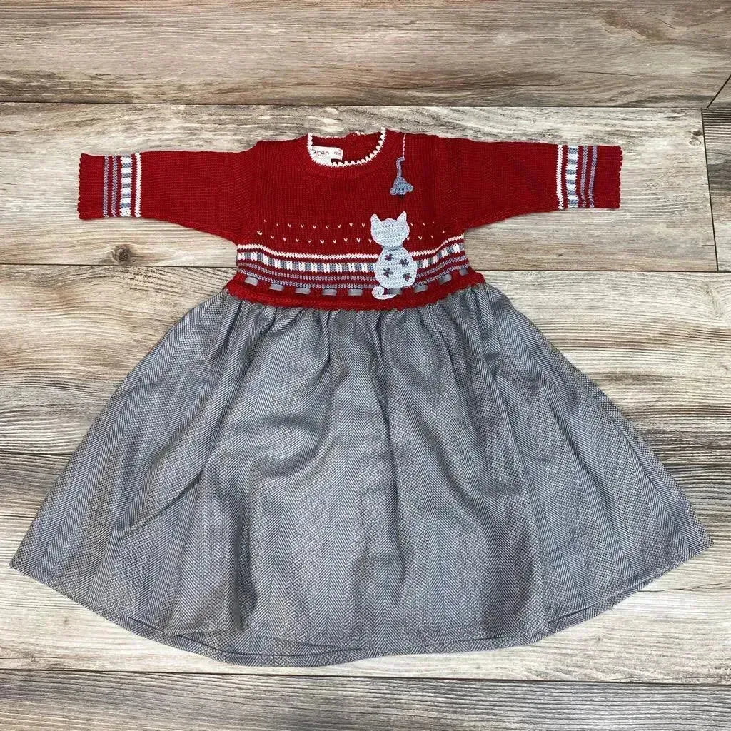 Flat lay of red sweater dress size 12 months with cat applique and gray herringbone skirt on light wood floor