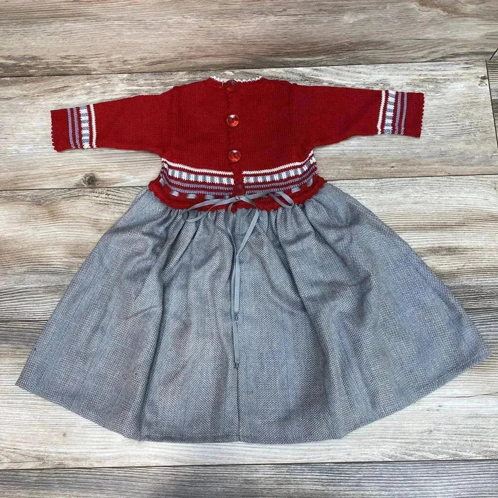 Top-down view of handmade red knit 12m sweater dress with buttoned bodice, striped cuffs and gray herringbone skirt on wood