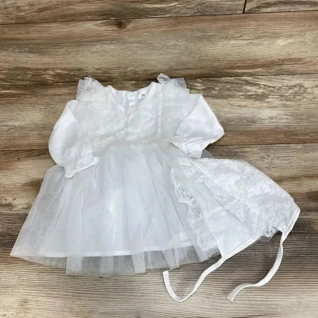 Top view of NWoT tulle overlay dress and bonnet size 6 to 9 months showcasing white tulle and 100 percent cotton long sleeves on wood