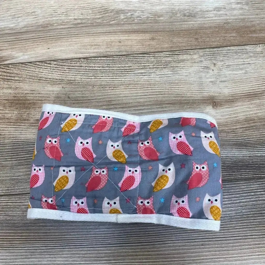 Front view of Anna & Eve baby swaddle strap showcasing colorful owl print and white trim on a wood-grain background