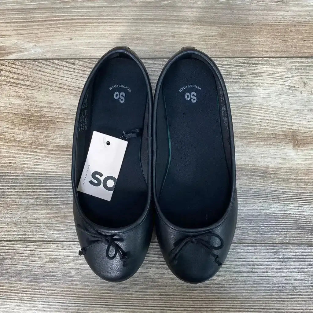 Top-down view of pair of black toddler ballet flats (size 2Y) showing front bows and brand tag on wood floor