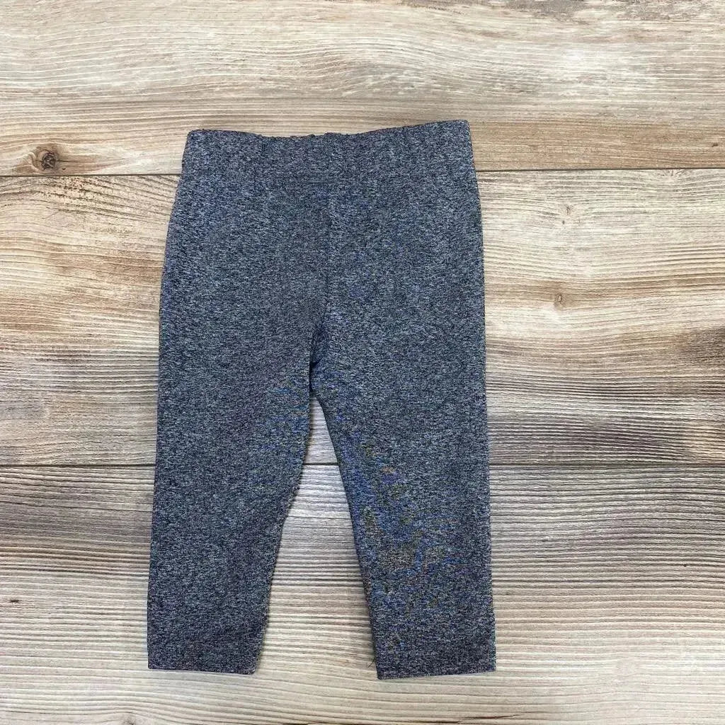 Front view of Puma leggings size 6 to 9 months showcasing full length and elastic waistband on a wood background