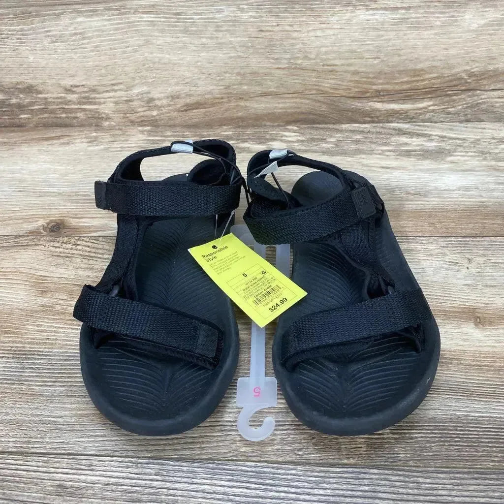 Top view of black All in Motion Everest sandals, size 5Y, with Velcro straps and textured footbed on wood background