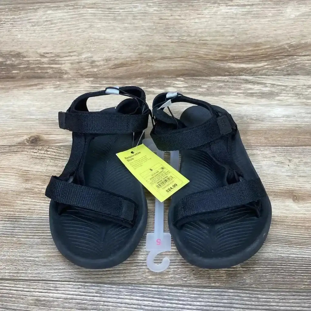 Top view of black All in Motion Everest sandals, size 5Y, with Velcro straps and textured footbed on wood background