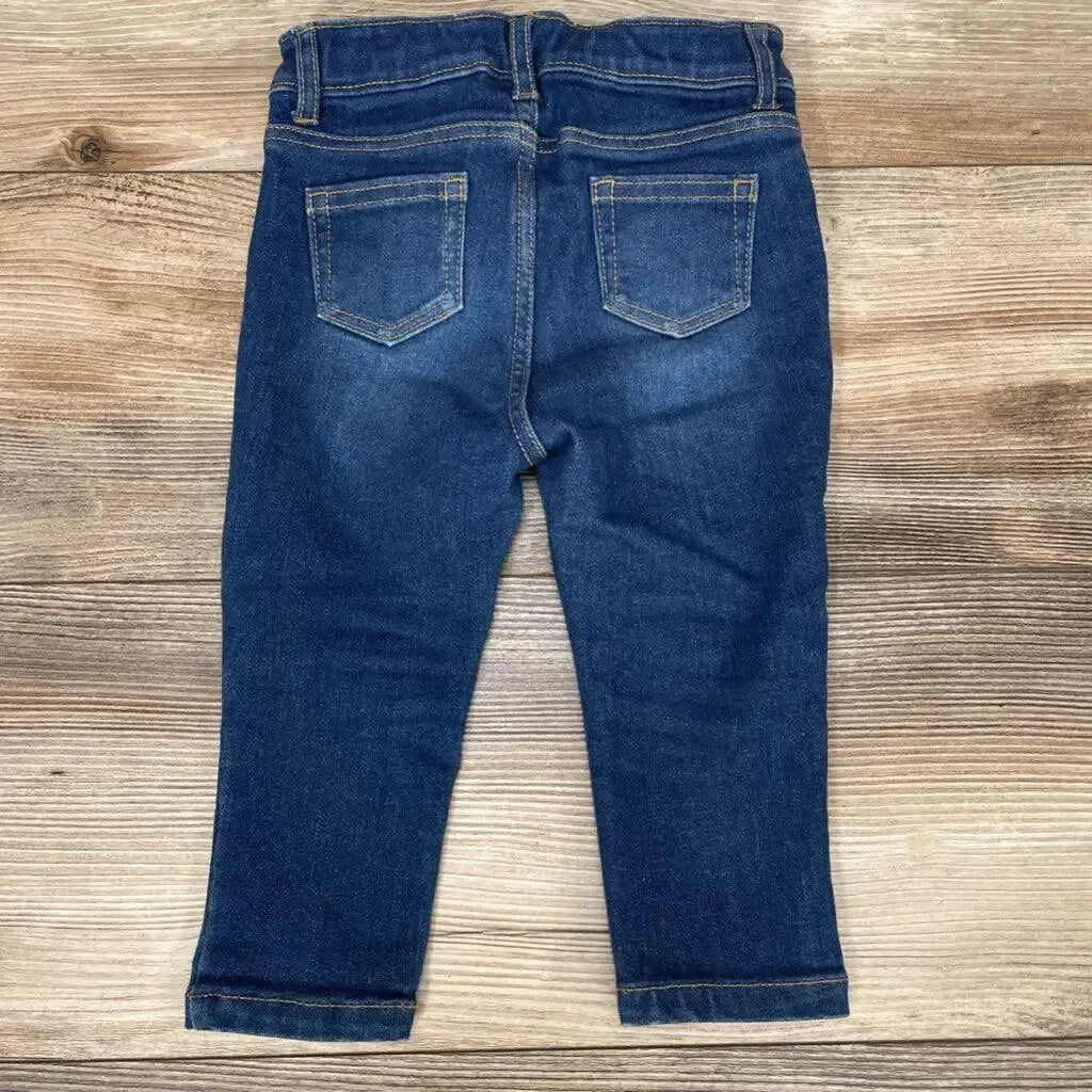 Back view of Jack denim skinny jeans 12-18m showcasing tapered skinny legs and two back patch pockets on a light wood background