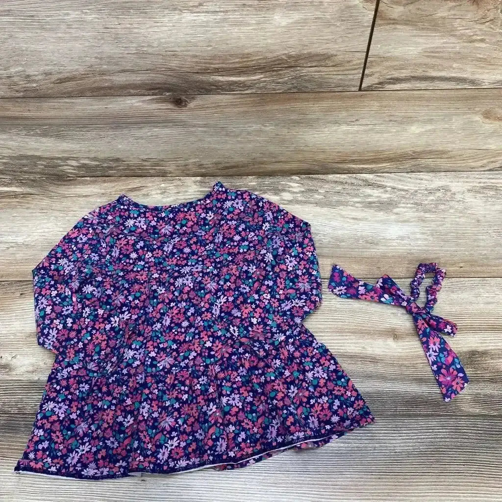 Flat lay of Crewcuts floral tunic and matching scrunchie showcasing the all-over floral print on a wood background