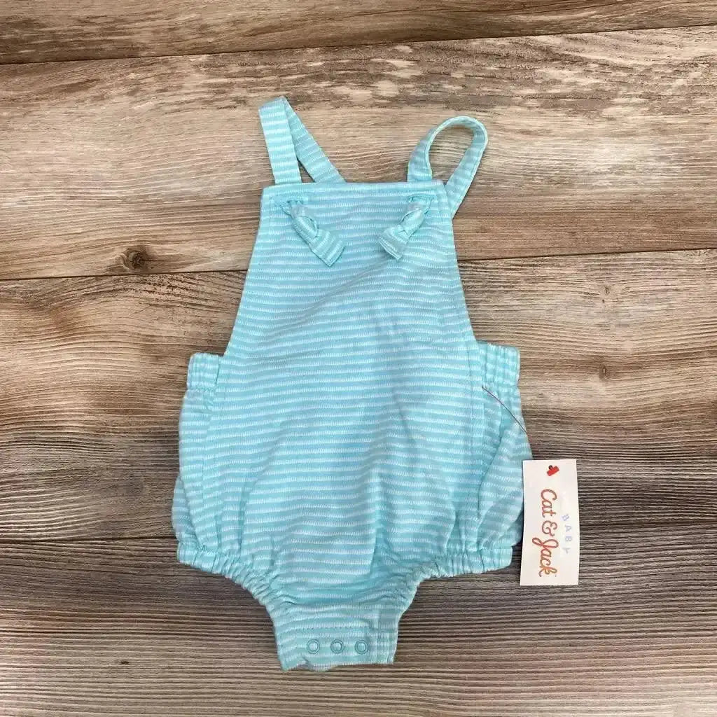 Flat lay of NEW Cat and Jack Textured Bubble Romper in aqua and white stripe showcasing tie shoulder straps and snap crotch with hangtag on wood plank floor