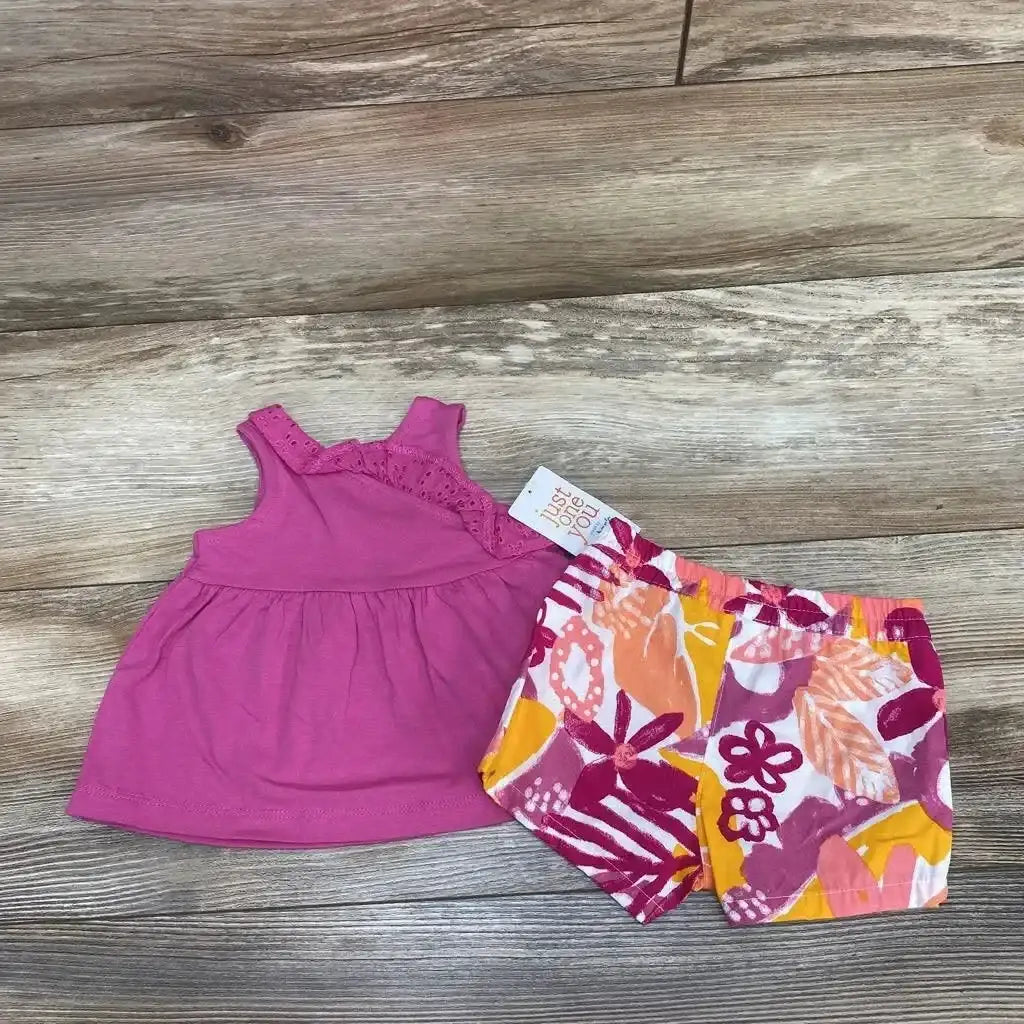 Front view of a 2pc tank top and floral shorts set with pink lace trim and colorful floral print on wood flooring