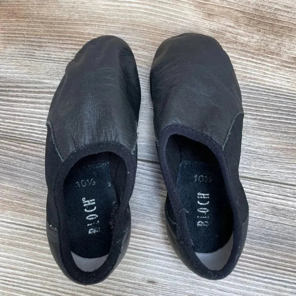 Top-down of used black Bloch Neo-Flex slip-on leather jazz shoes showing elastic side panels and size 10.5 on wood floor