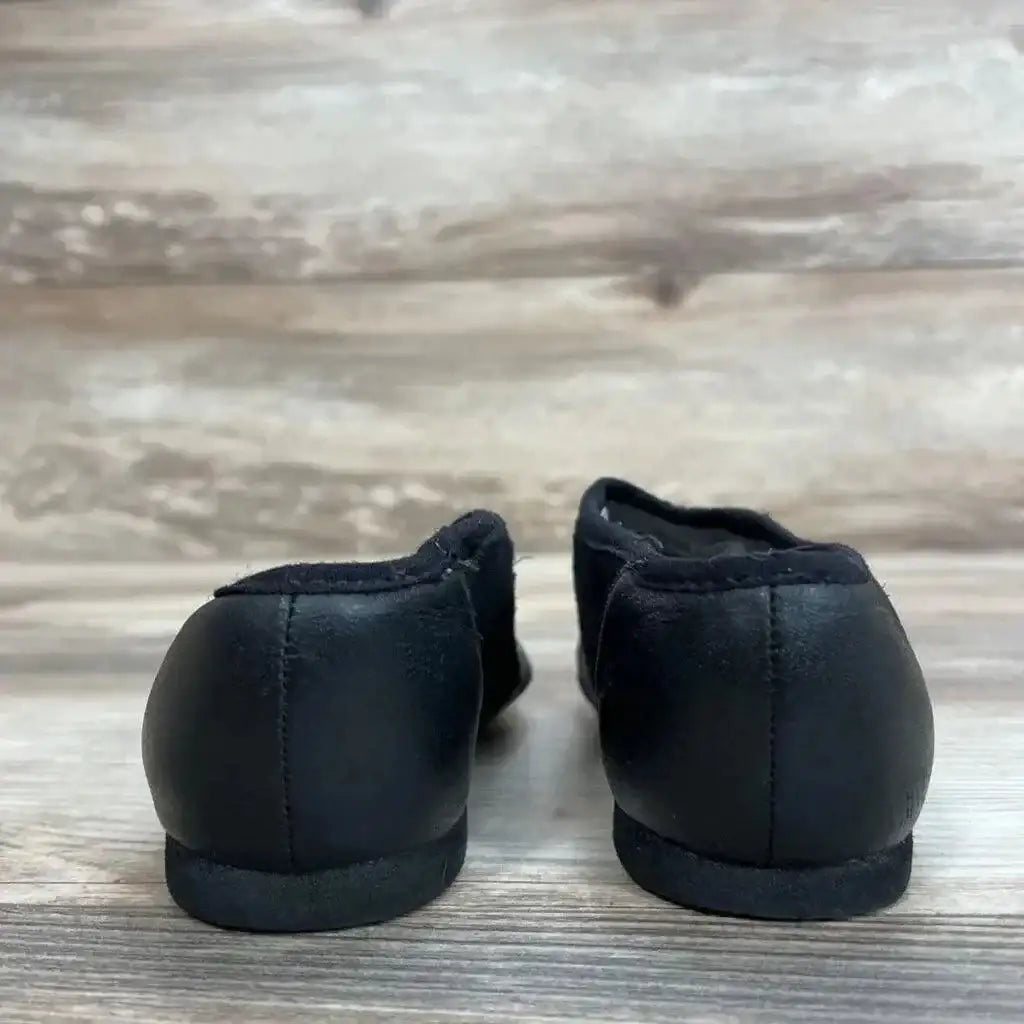 Rear view of black Bloch Neo-Flex slip-on leather jazz shoes size 10.5 showing low heel and elasticized topline on wood plank background
