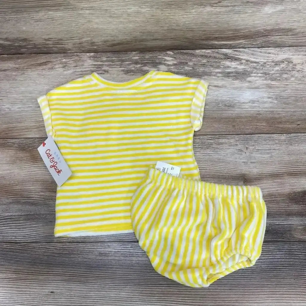 Top-down view of Cat & Jack 2pc yellow-and-white striped terry shirt and shorts, size 3-6M, showing chest pocket and elasticized waist on wood background