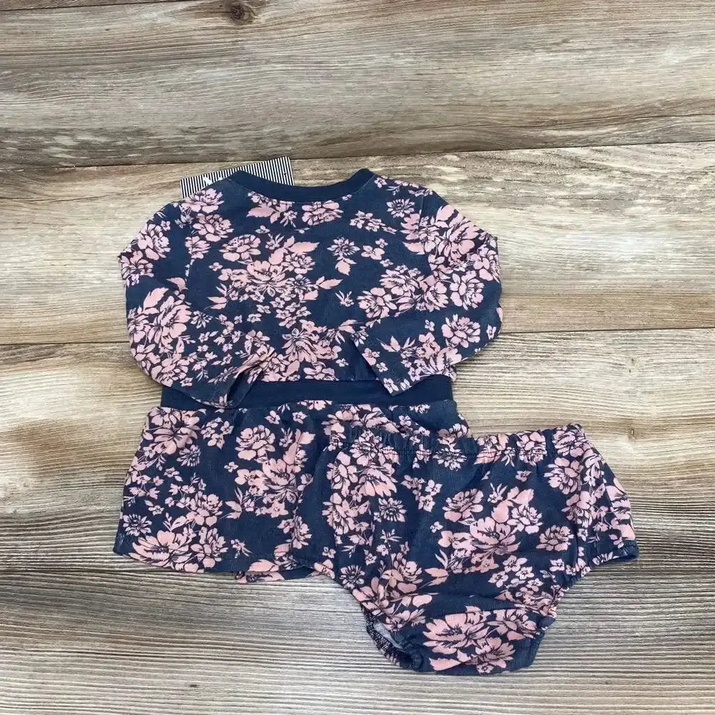 Flat lay of Splendid floral baby dress and matching bloomers showcasing long sleeves and pink floral print on wooden background