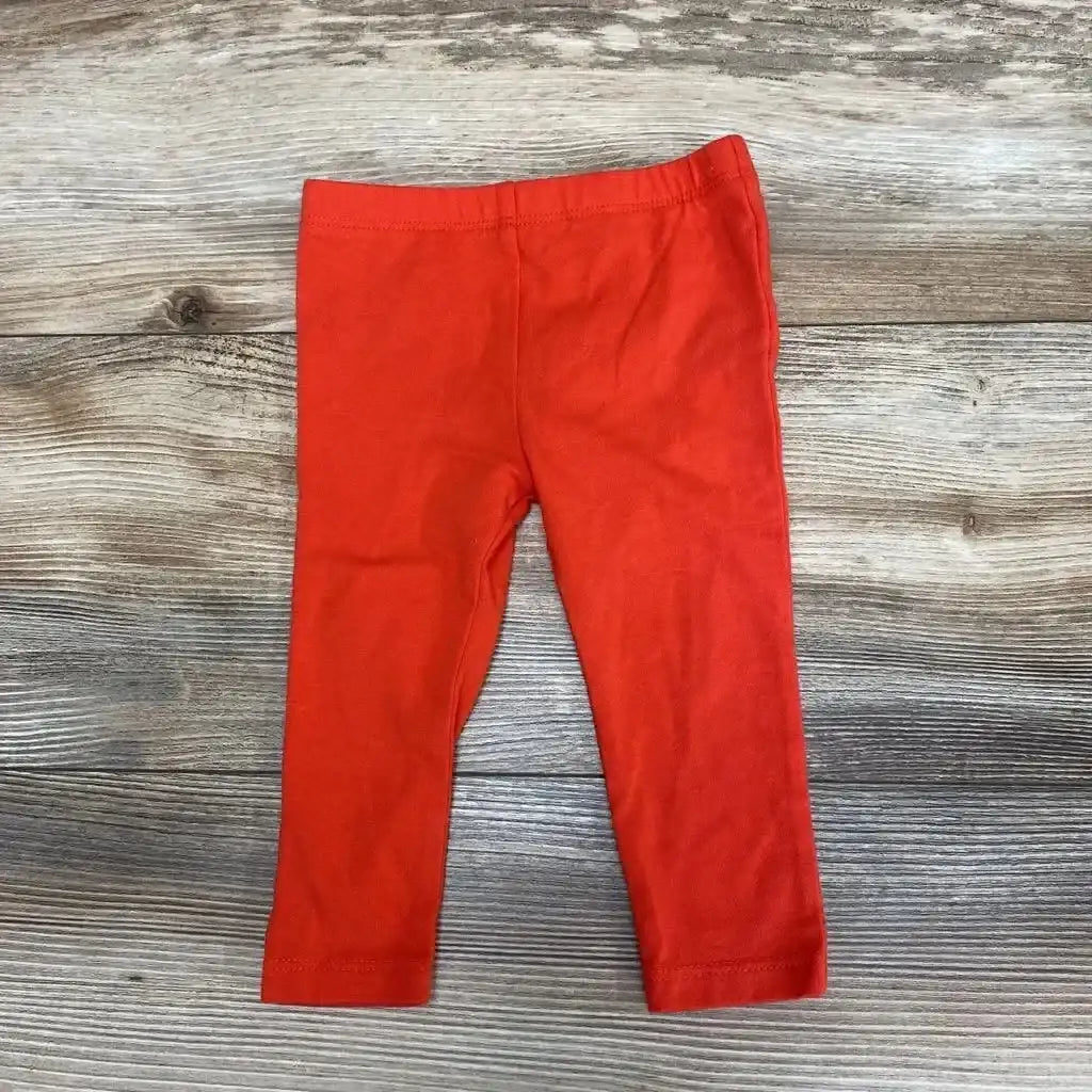 Flat-lay of Cat & Jack baby leggings in red showcasing elastic waistband and straight-leg fit on wood background