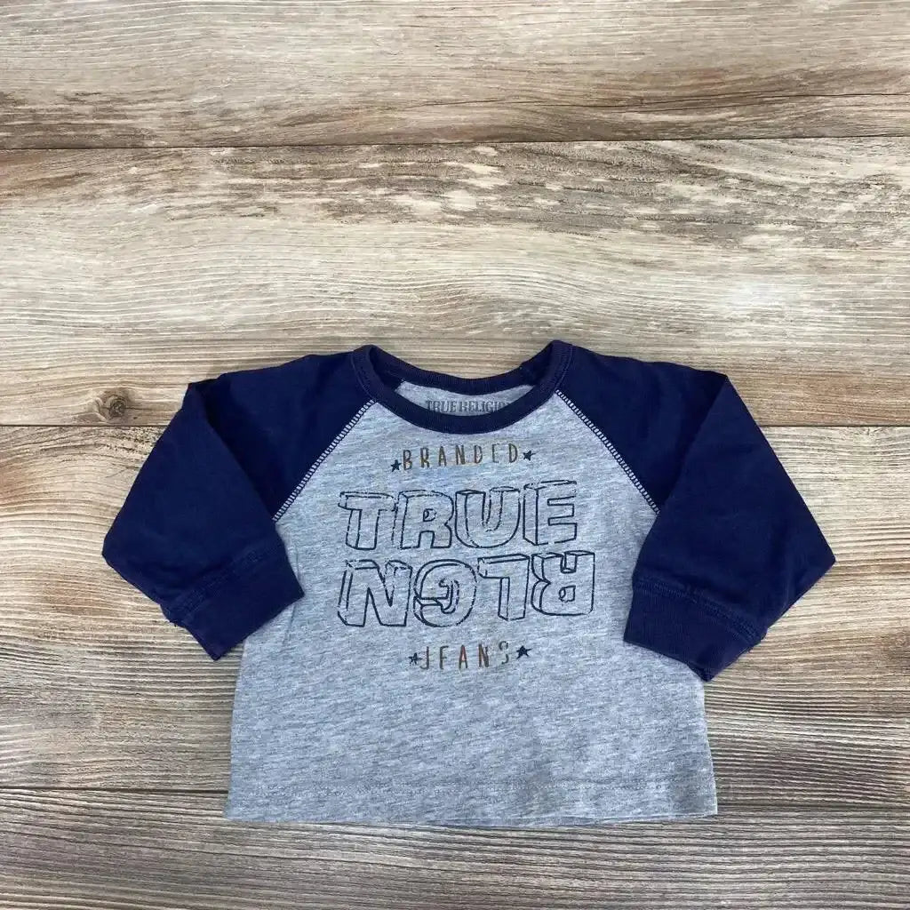 Flat lay of True Religion baby shirt size 6 months showing navy raglan sleeves and heather gray body with TRUE RELIGION chest print on wood background