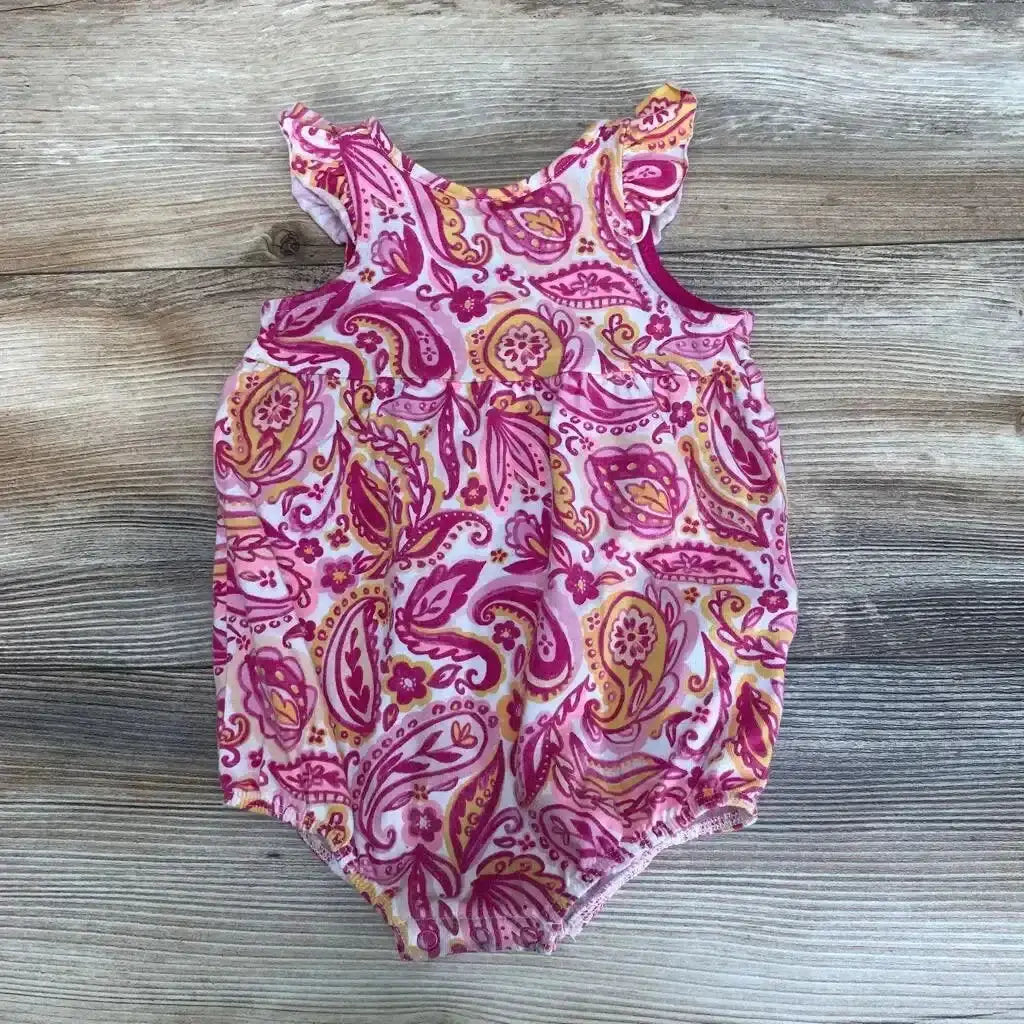 Front view of Cat & Jack paisley floral romper in size 3 to 6 months showcasing ruffled shoulders on a wood-grain background