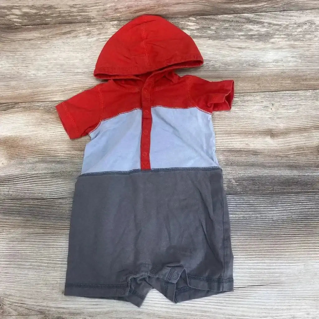 Flat lay of TEA hooded colorblock romper 3-6m with red hood, light blue middle, gray bottom and crotch snaps on wood floor